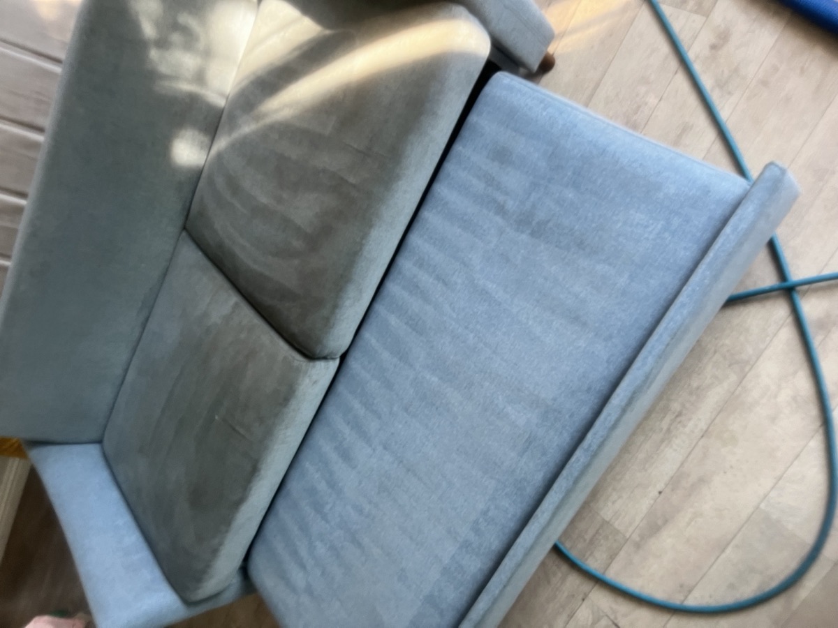 Light blue sofa half cleaned, half still soiled