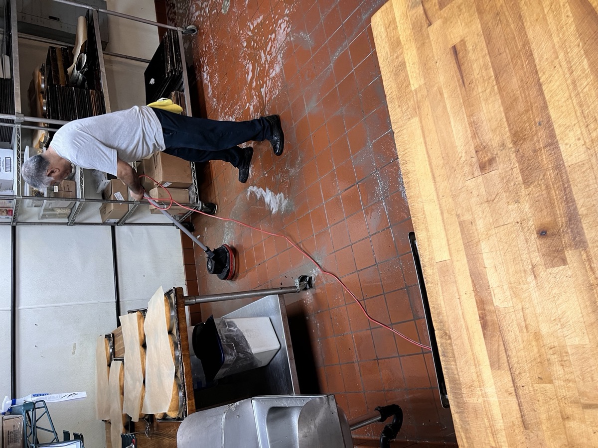 Commercial kitchen floor being deep-cleaned after hours